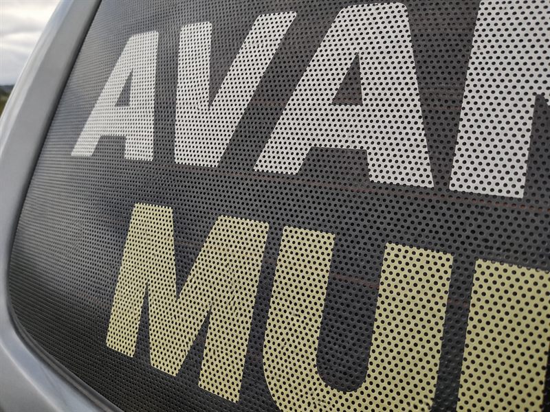 Detalhe da malha de furos do vinil microperfurado aplicado no vidro traseiro de um carro